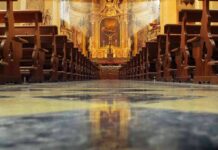 Livestream Catches Priest’s FINAL Moments at Mass Church interior with wooden pews facing ornate altar