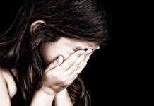 Child covering face with hands