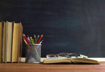 Governor Kathy Hochul DEFIES Teachers Unions to Back Trump Plan Books and pencils on a desk in front of a chalkboard