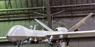 military drone with missiles suspended in a hangar