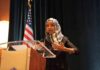 Ilhan Omar speaking at a podium with a microphone