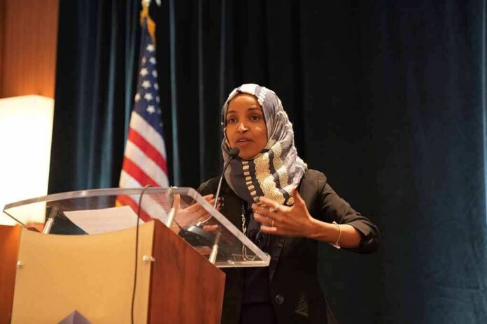 shutterstock_1311568823 Ilhan Omar speaking at a podium with a microphone