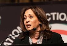 Kamala Harris speaking at a podium with a microphone