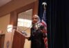 Ilhan Omar speaking at a podium with a microphone