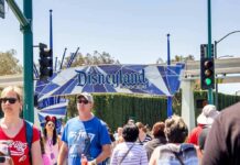DEAD Man Found at Disneyland’s Gate Crowd walking past a Disneyland Resort entrance sign