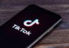 TikTok ‘Demonologist’ Accused of TRACKING Women smartphone displaying the TikTok app logo on screen