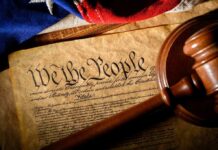 U.S. Constitution with gavel and flag
