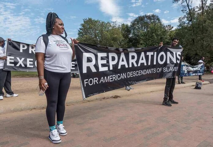 shutterstock_2058693902 Protesters holding a large reparations banner outdoors