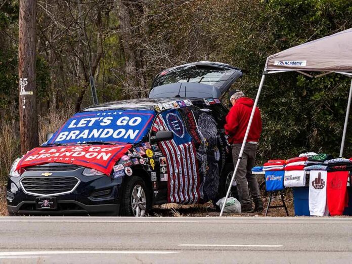 Street vendor with car covered in political banners selling T-shirts