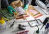 Forensic technician handling evidence bags on a lab table