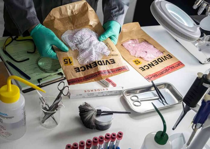 Forensic technician handling evidence bags on a lab table