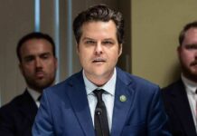 Matt Gaetz speaking at a microphone during a formal meeting