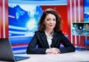 News anchor seated at a broadcast desk
