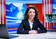 News anchor seated at a broadcast desk
