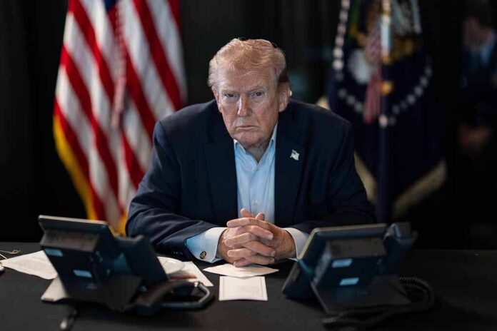 Donald Trump seated at a table between two desk phones