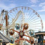 Colorful amusement park scene featuring a ferris wheel and carousel