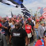 Dennis Erickson, Carlos Hyde, and Danny Hope among a crowd at a patriotic rally