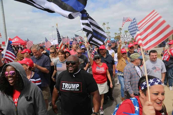 Dennis Erickson, Carlos Hyde, and Danny Hope among a crowd at a patriotic rally
