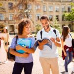College students walking on campus with books and backpacks
